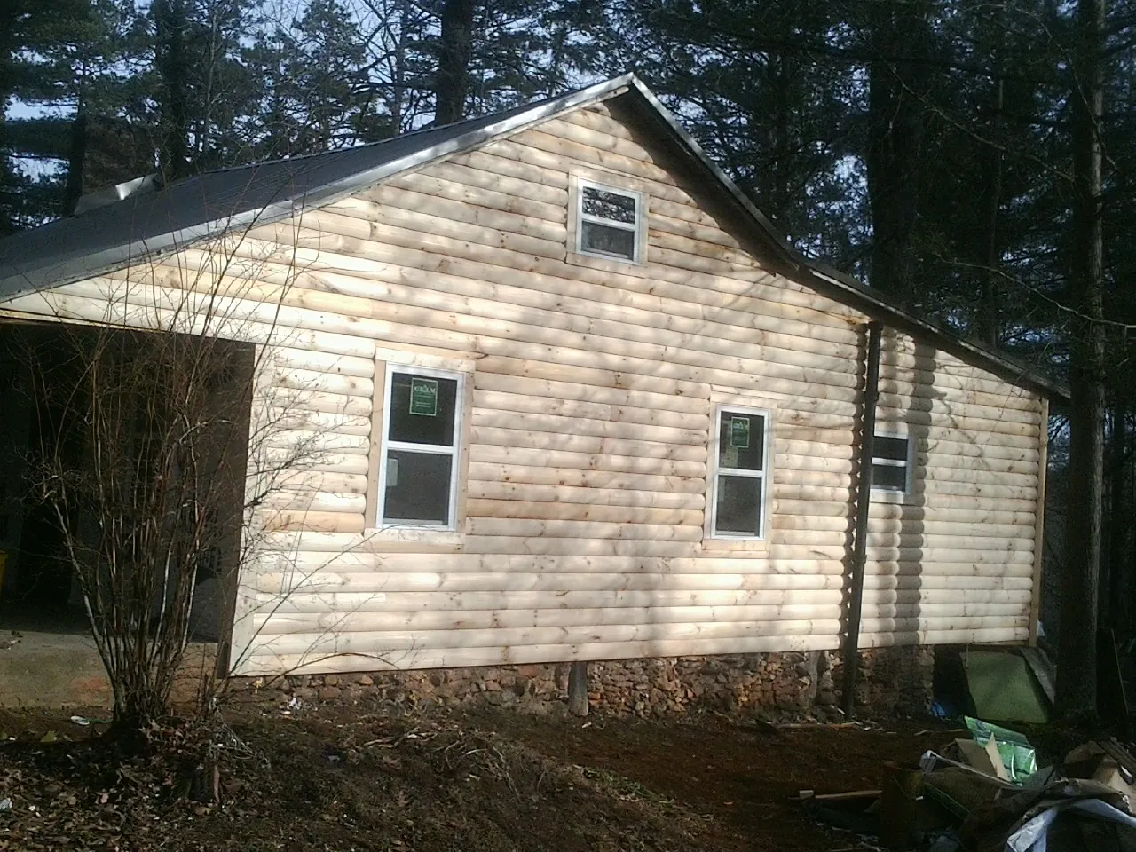 New log siding and dark metal roofing on a gable end in Smithmill