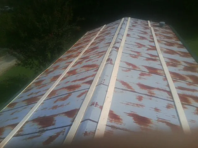Rusted metal roof panels with new wood purlins before replacement — Storm Damage Roof Repair in Smithmill by Roofing Brothers