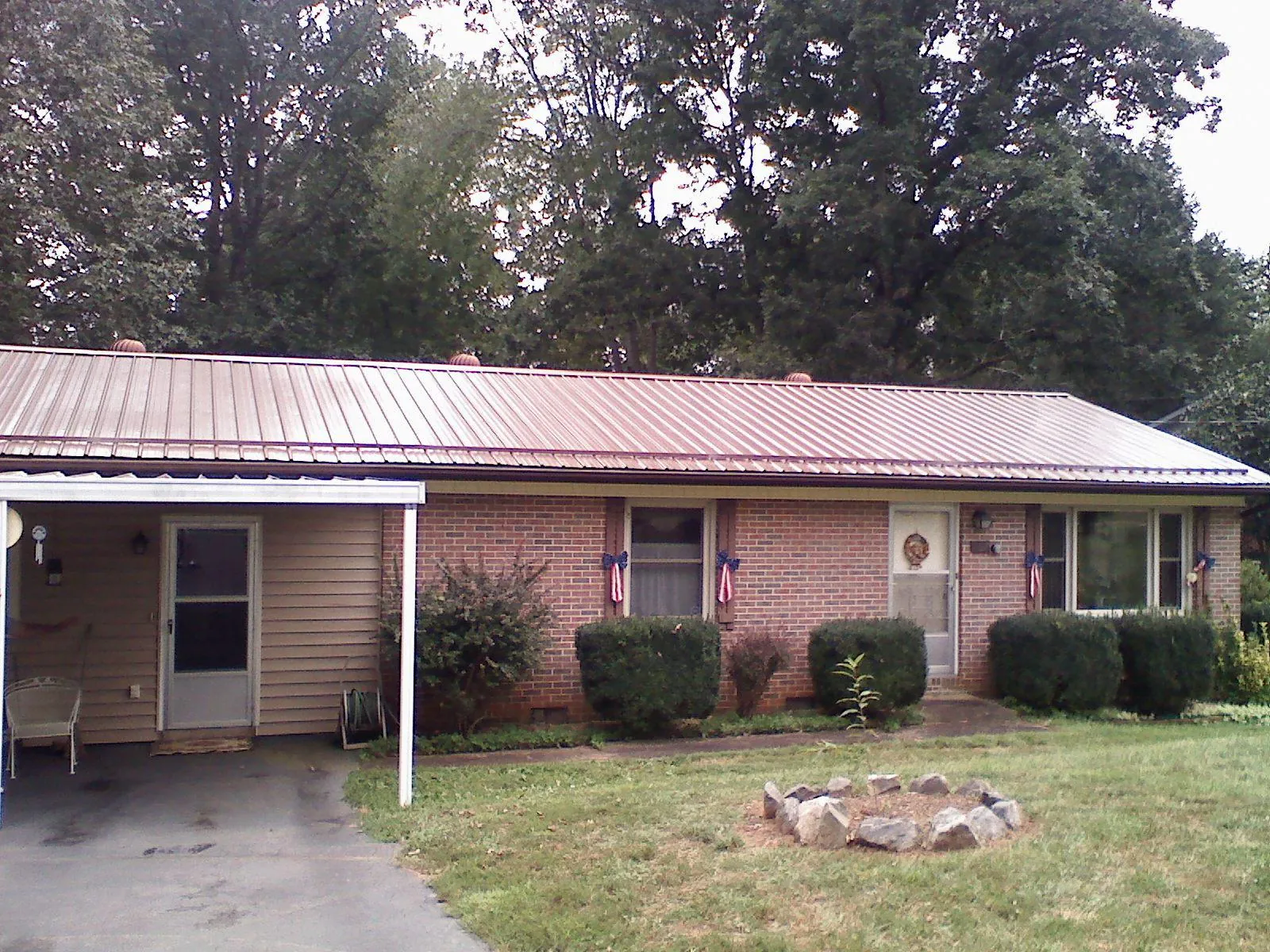 Bronze metal roof and carport on a brick ranch home — Roof Repair work by our crew in Smithmill